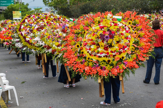 Silleteros carrying colorful flower arrangements during Feria de las Flores in Medellín